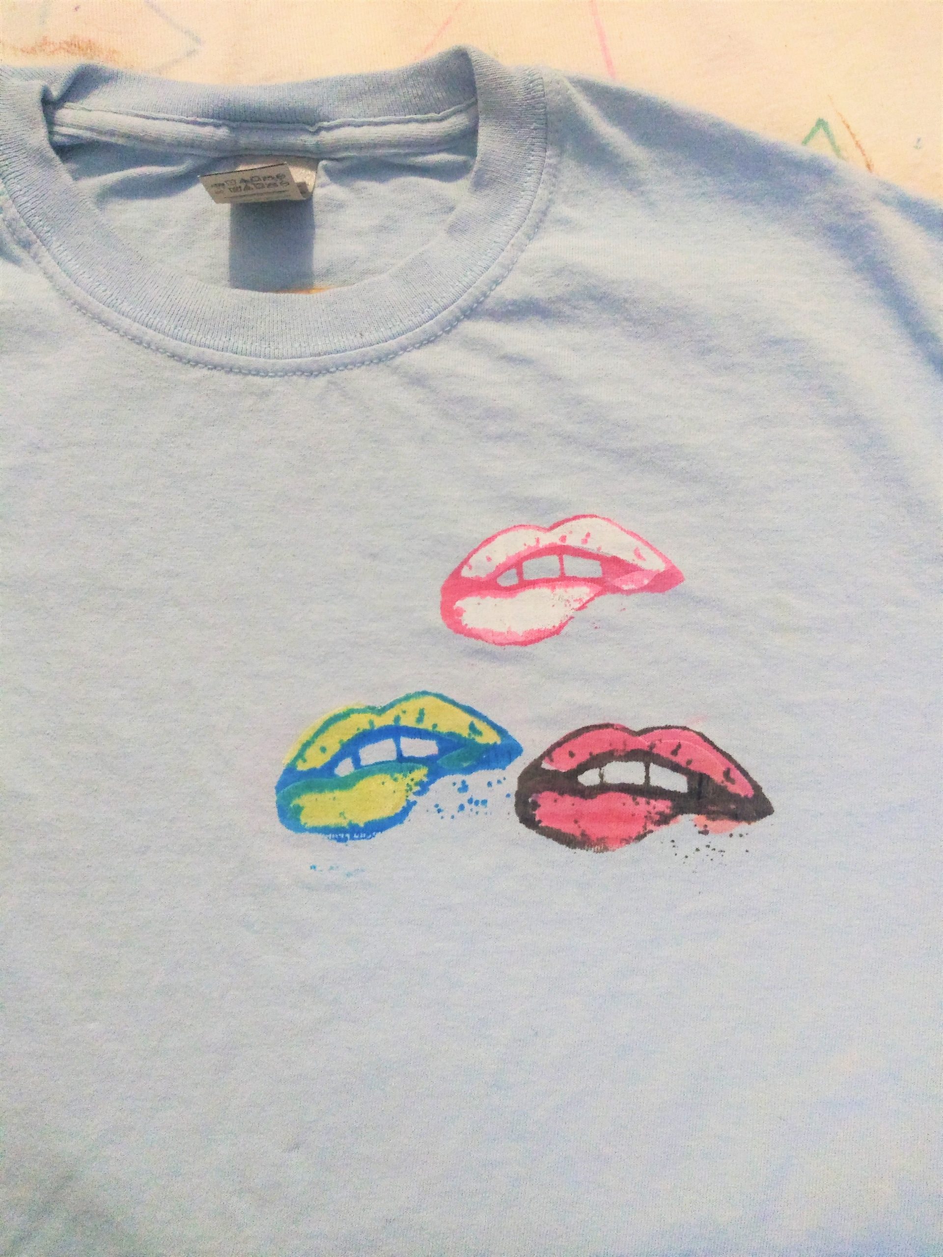 Close up of blue tshirt with printed mouths lower lip bite.