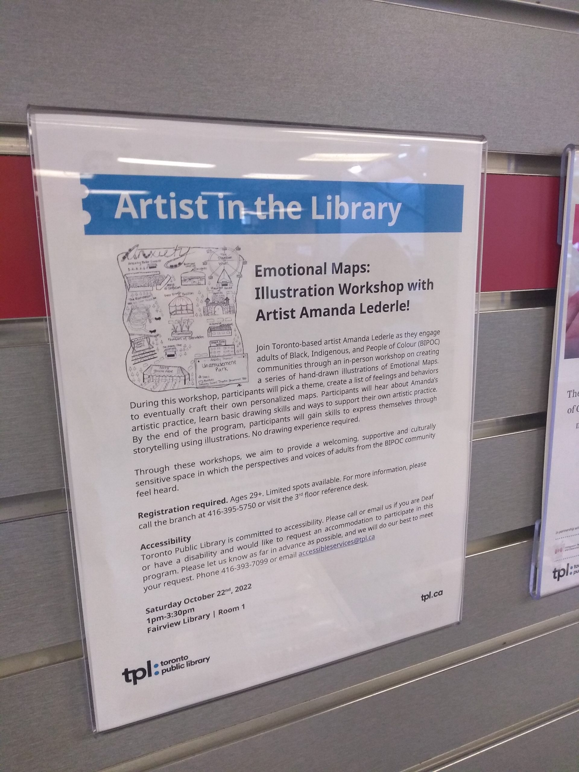 A photo of the Artist in the Library poster in a plexi glass mounted on a wall.
